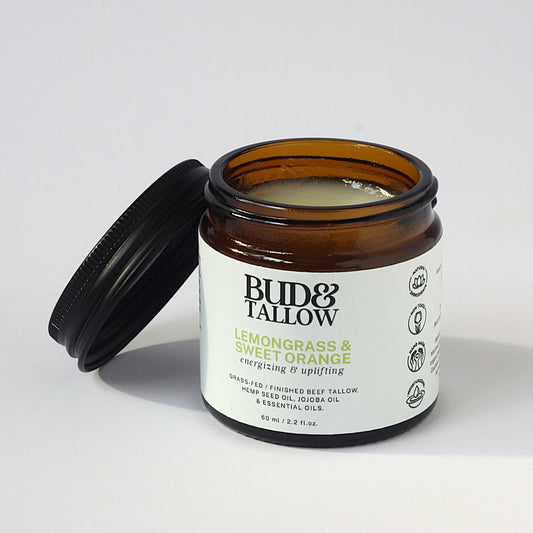 Jar of Bud & Tallow lemongrass and sweet orange with lid off on white background