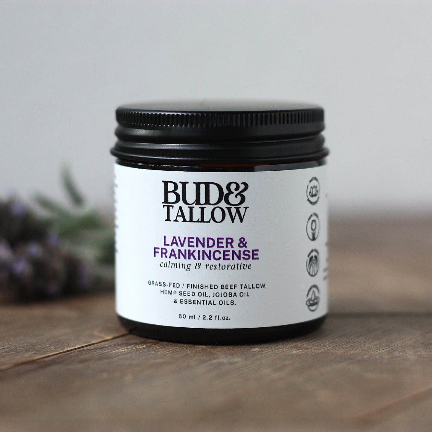 Bud & Tallow lavender and frankincense product on a wooden surface with a blurred background