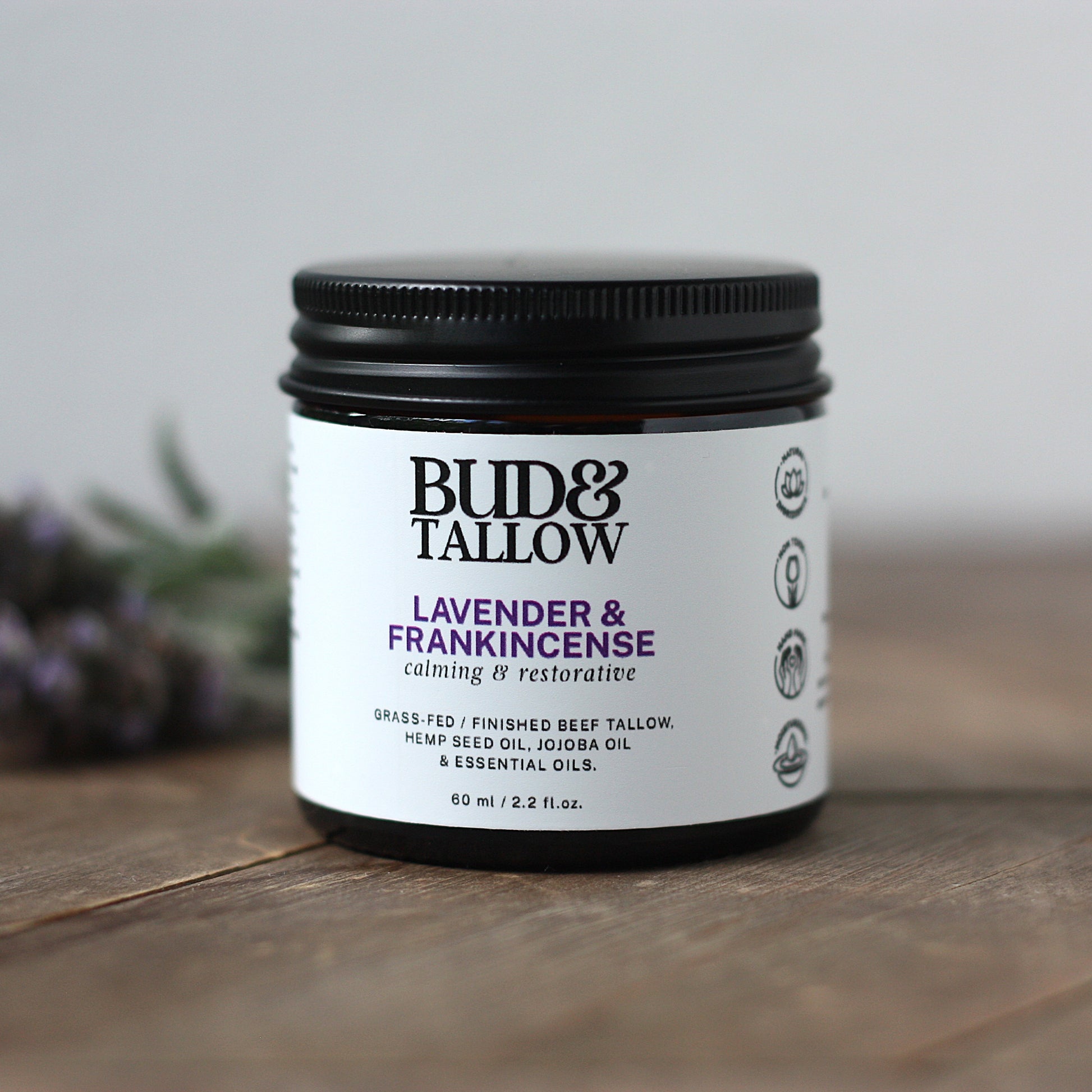 Bud & Tallow lavender and frankincense product on a wooden surface with a blurred background