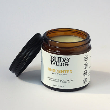 Jar of unscented Bud & Tallow with lid off on white background